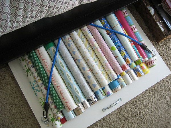 Bungee Cords Board for Wrapping Paper Storage Under the Bed. A board with bungee cords under your bed can be a great storage solution for the wrapping paper without dust. Keep it smooth and clean so you will not have to buy new gift wrap every time you wrap a present. 